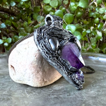 Sculptural heart pendant necklace with central purple Amethyst, dark textured setting and polished Hematite stones.