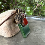 Large green Jade pendant necklace with red Carnelian stones in a handcrafted sculptural amulet setting.