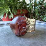 Wide statement cuff bracelet with an exceptionally large natural Sardonyx displaying red, rust, cream and white banded patterns.