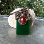 Large green Jade pendant necklace with red Carnelian stones in a handcrafted sculptural amulet setting.