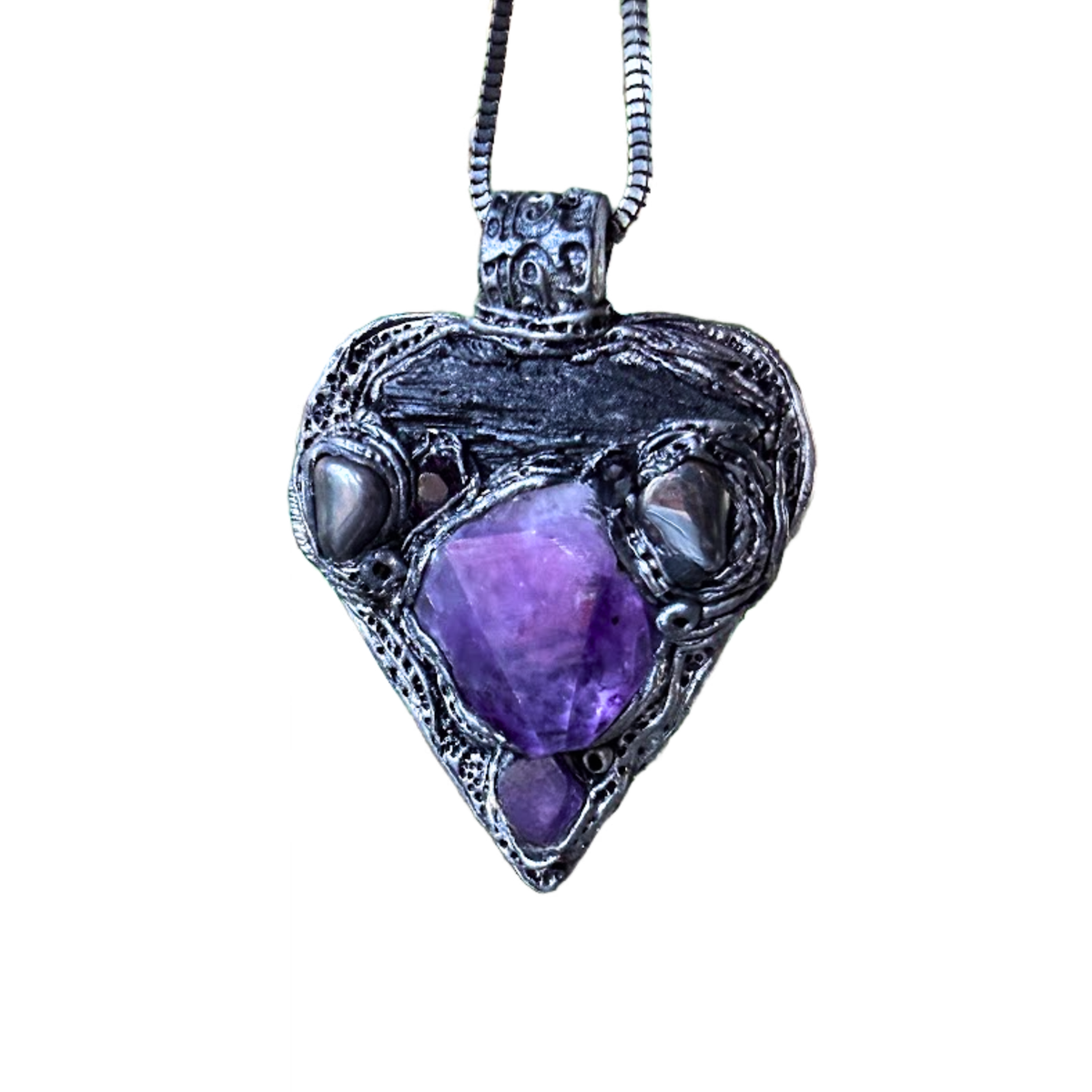 Sculptural heart pendant necklace with central purple Amethyst, dark textured setting and polished Hematite stones.
