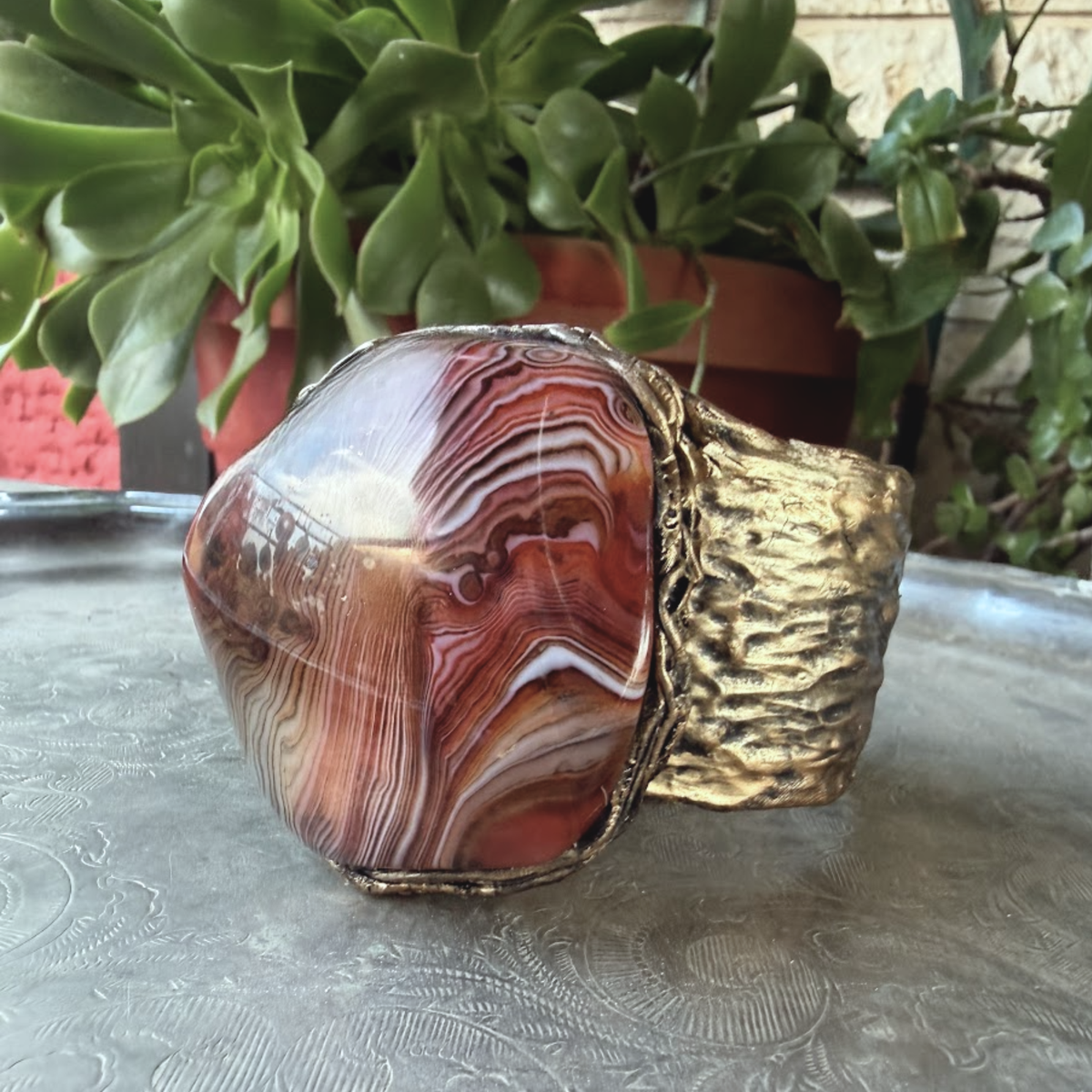 Wide statement cuff bracelet with an exceptionally large natural Sardonyx displaying red, rust, cream and white banded patterns.