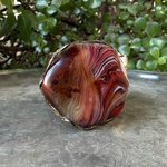 Wide statement cuff bracelet with an exceptionally large natural Sardonyx displaying red, rust, cream and white banded patterns.