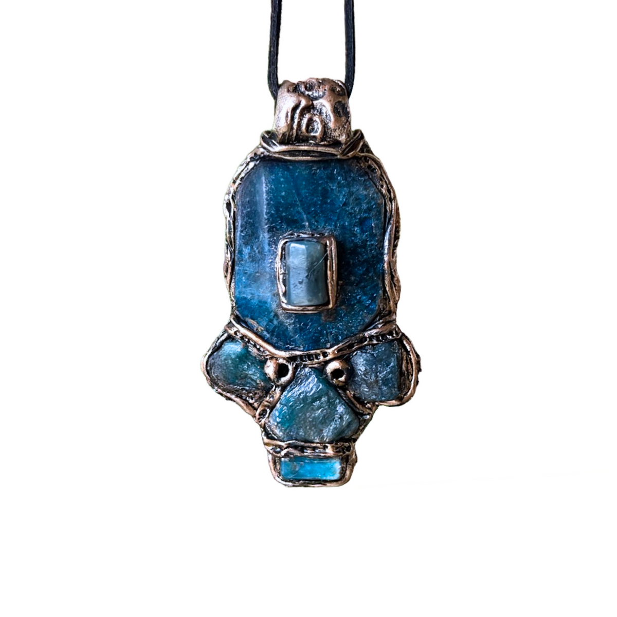 Handmade Blue Apatite pendant necklace combining raw and polished blue gemstones with contrasting textures in an ornate antique bronze-tone polymer clay setting on a black cord.
