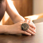 Chunky Amber and Ammonite fossil statement ring with warm honey tones and spiral fossil design.
