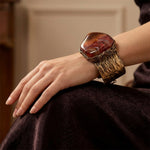 Wide statement cuff bracelet with an exceptionally large natural Sardonyx displaying red, rust, cream and white banded patterns.